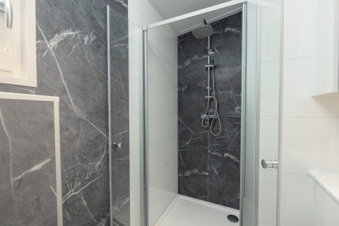 Moderne bruser på Loevestein med varme kar i Veluwepark de Bosgraaf, Nederlandene, grå og hvide fliser.