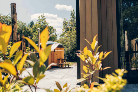 Vue extérieure d'une tiny house en bois avec bain à remous à Veluwepark de Bosgraaf, aux Pays-Bas.