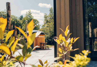Vue extérieure d'une tiny house en bois avec bain à remous à Veluwepark de Bosgraaf, aux Pays-Bas.