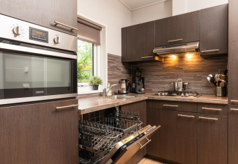 Cucina moderna al Sand Lodge Comfort presso Veluwepark de Bosgraaf, Paesi Bassi, con lavastoviglie aperta.