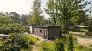 Heather Lodge mit modernem Design, umgeben von grüner Natur, Bäumen und Spazierwegen in ruhiger Lage.