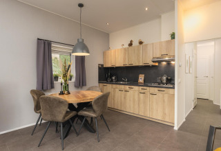 Cocina y comedor modernos en Heather Lodge, en Veluwepark de Bosgraaf, Países Bajos, con detalles en madera.