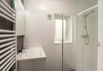 Modernes Bad mit Glasdusche, rechteckigem Waschbecken, weißen Fliesen und Fenster in Heather Lodge, Veluwe.