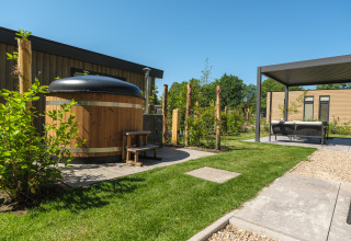 Udendørs område med spabad og overdækket lounge ved Loevestein Deluxe på Veluwepark de Bosgraaf, Holland.