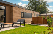 Außenbereich der Lodge Cannenburch mit Whirlpool und Sitzgelegenheiten im Veluwepark de Bosgraaf.