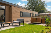 Espace extérieur du lodge Cannenburch avec bain à remous et sièges à Veluwepark de Bosgraaf, Pays-Bas.