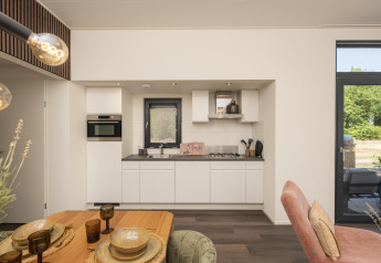 Moderne køkken og spiseområde på Lodge Cannenburch med boblebad ved Veluwepark de Bosgraaf i Holland.