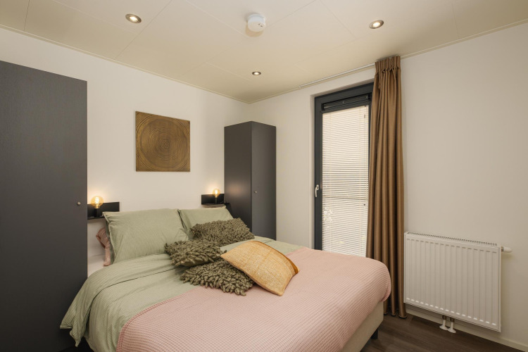 Schlafzimmer in der Cannenburch-Lodge mit stilvollem Interieur im Veluwepark de Bosgraaf, Niederlande, mit Hot Tub.