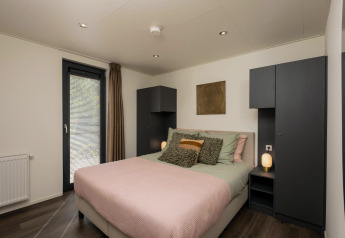 Dormitorio en Lodge Cannenburch con decoración moderna y cálida en Veluwepark de Bosgraaf, Países Bajos, jacuzzi.