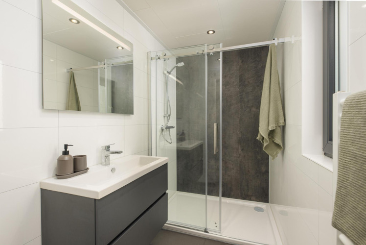 Modernes Badezimmer mit Dusche und Spiegel in der Cannenburch-Lodge, Veluwepark de Bosgraaf, Niederlande.