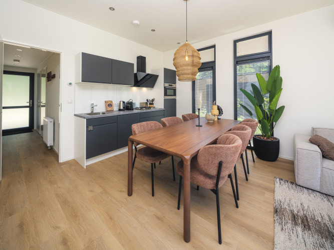 Cocina y comedor modernos en la lodge Essenburgh Comfort con jacuzzi en Veluwepark de Bosgraaf, Países Bajos.