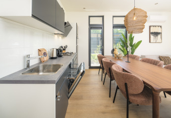 Modern kitchen and dining area at Essenburgh Comfort lodge with hot tub in Veluwepark de Bosgraaf, Netherlands.