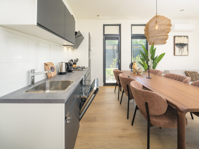 Moderne keuken en eetgedeelte in de Essenburgh Comfort lodge met hottub op Veluwepark de Bosgraaf, Nederland.