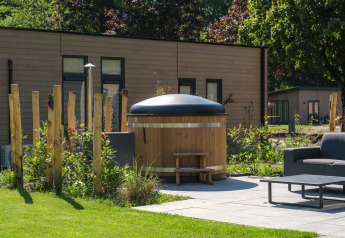 Outdoor photo of Essenburgh Deluxe lodge with hot tub at Veluwepark de Bosgraaf in the Netherlands.