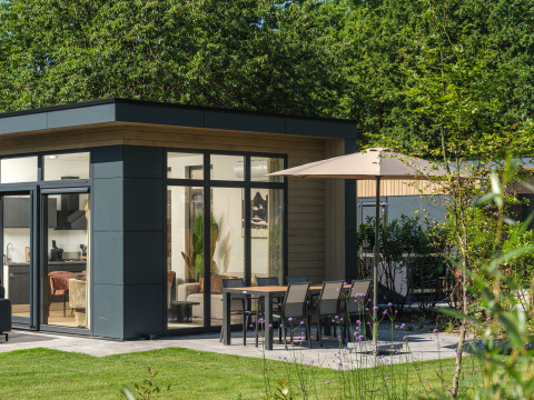 Modern Essenburgh Deluxe lodge with outdoor dining and garden at Veluwepark de Bosgraaf, Netherlands.