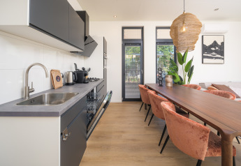 Moderne Küche und Essbereich in der Essenburgh Deluxe Lodge mit stilvollen Möbeln im Veluwepark de Bosgraaf.