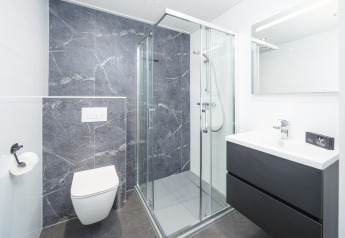 Bagno moderno a Essenburgh Deluxe con doccia in vetro e arredi di design nel Veluwepark de Bosgraaf.
