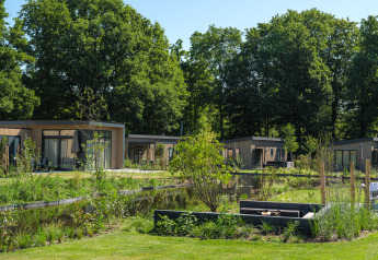 Moderni lodge con vasca idromassaggio al Veluwepark de Bosgraaf, Paesi Bassi, immersi nel verde e laghetti.
