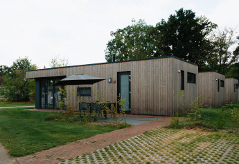 Moderne trælodge ved Happy Oak Lodge, Holiday Park Mölke, med terrasse og grønne omgivelser i Holland.
