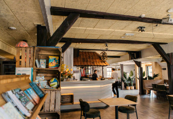 Gemütliches Glamping-Interieur mit Loungebereich, Bar, Regalen und viel natürlichem Licht.