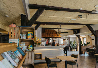 Gezellig interieur van een glampingverblijf met zithoek, bar, boekenplanken en kamerplanten.