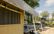 Tienda safari con parque infantil al fondo en Recreation Park Den Blanken, Países Bajos, un día soleado.