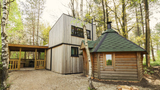 Cabaña moderna y sauna tradicional entre árboles en Cosy Cabins, bosque de Limburg, Bélgica.