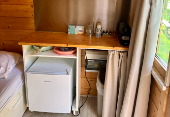 Küchenecke einer Blockhütte mit kleinem Kühlschrank und Kaffeemaschine bei Urban-Gardens Ieper, Belgien.