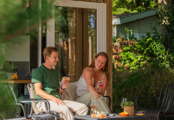 Due persone giocano a carte e si rilassano sulla veranda di Sand Lodge Jacuzzi al De IJsvogel, Paesi Bassi.