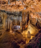 Drypstenshule nær Medulin i Istrien, Kroatien, med imponerende stalaktitter, stalagmitter og oplyste formationer.