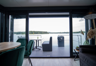 Uitzicht vanuit de leefruimte op Houseboat Marina Mookerplas met modern interieur en zicht op het meer.