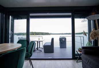 Vista desde la sala del Houseboat Marina Mookerplas con interior moderno y paisaje de lago en los Países Bajos.