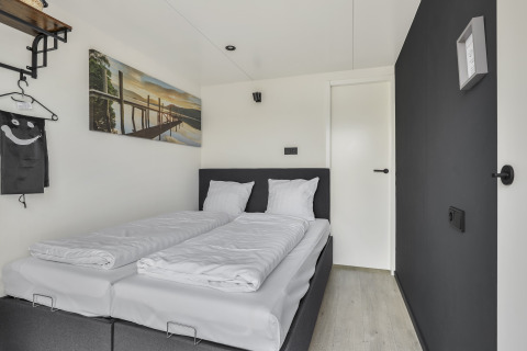 Modern bedroom interior on Houseboat Marina Mookerplas in the Netherlands, featuring a double bed and wall art.