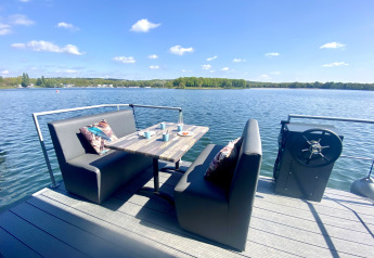 Buiten zitgedeelte op een woonboot bij Marina Mookerplas met tafel, zitbanken en uitzicht op het meer.