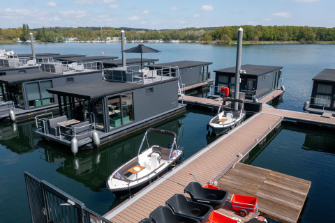Modernas casas flotantes con terrazas y embarcaciones atracadas en Marina Mookerplas, Países Bajos.