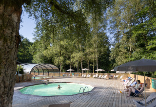 Udendørs poolområde omgivet af træer på Huttopia Caminos de Galicia feriepark i Galicien, Spanien.