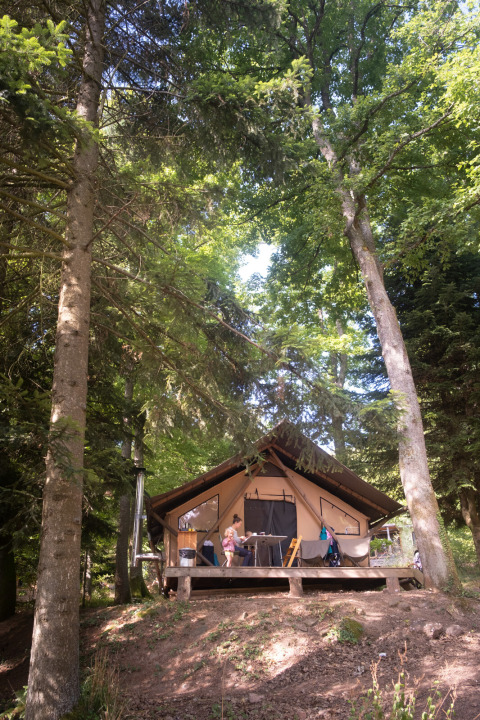 Tenda safari Trappeur a Huttopia Caminos de Galicia, Spagna, immersa tra alti alberi in un bosco