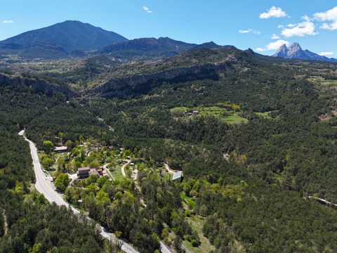 Luftaufnahme des Huttopia Barcelona Pirineos Ferienparks, umgeben von Bergen und Wäldern in Katalonien, Spanien.