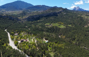 Vue aérienne du parc de vacances Huttopia Barcelona Pirineos, entouré de montagnes et de forêts en Catalogne, Espagne.