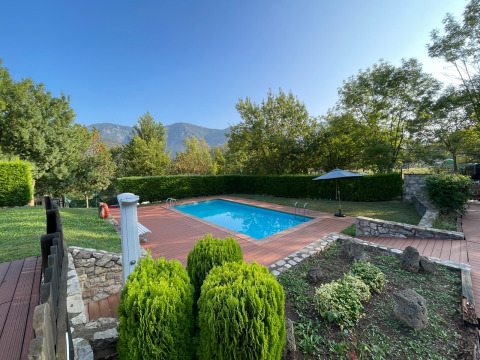 Piscina con terrazza in legno e vista montagna al parco vacanze Huttopia Barcelona Pirineos, Catalogna.