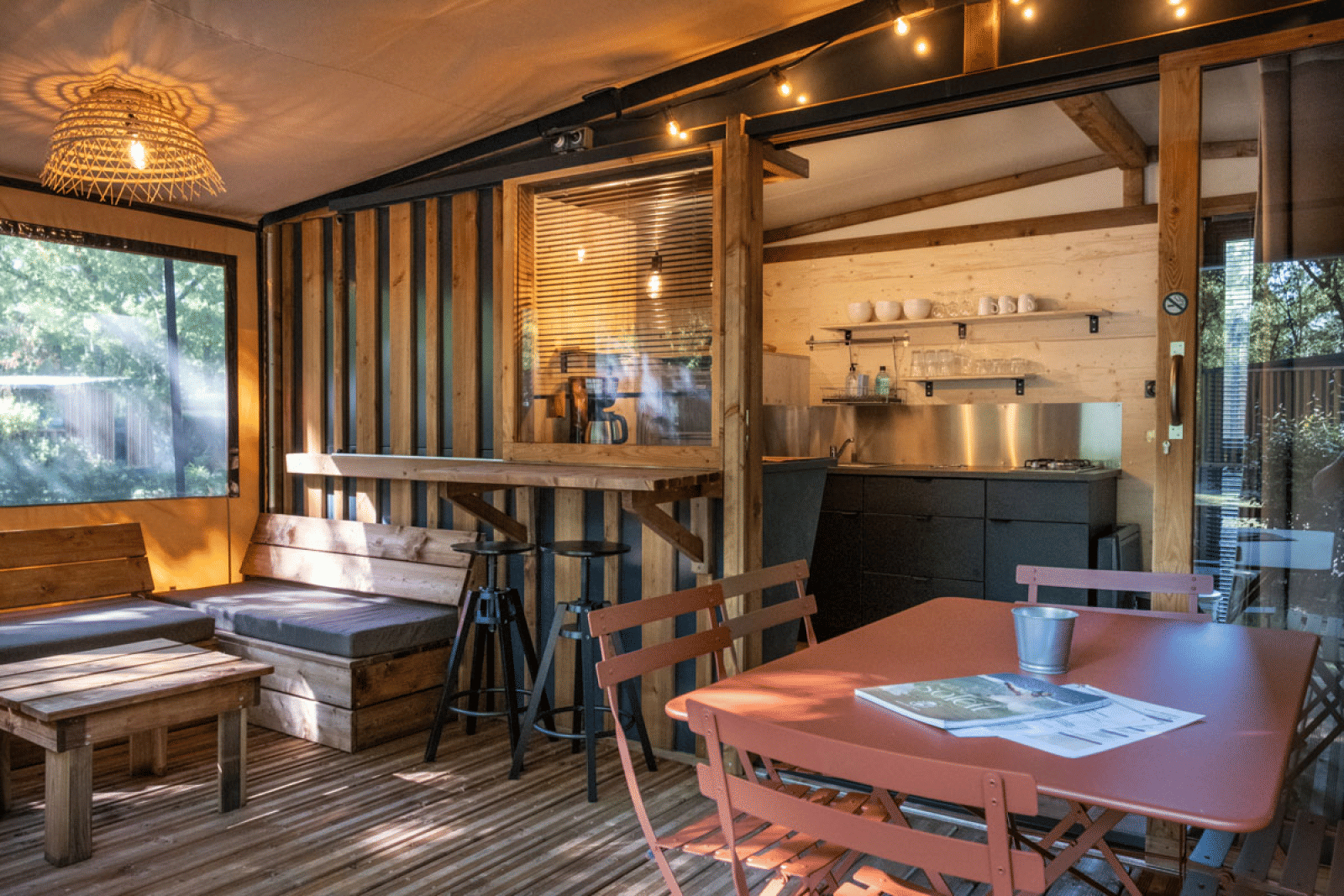 Gezellige glamping-accommodatie in Arizona met houten meubels, keukentje en sfeervolle verlichting.