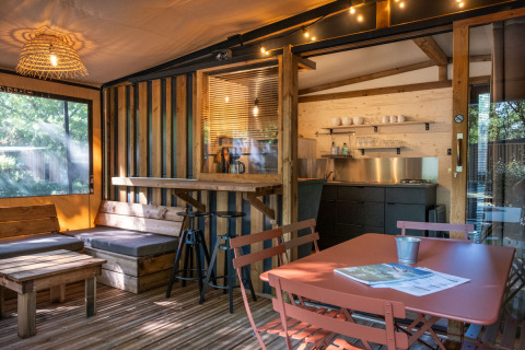 Alojamiento glamping en Arizona con muebles de madera, pequeña cocina y una cálida iluminación.