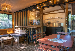 Alojamiento glamping en Arizona con muebles de madera, pequeña cocina y una cálida iluminación.