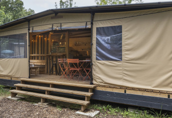 Safari teltet Arizona ved Huttopia Caminos de Galicia i Spanien, med træterrasse og udendørs siddepladser.
