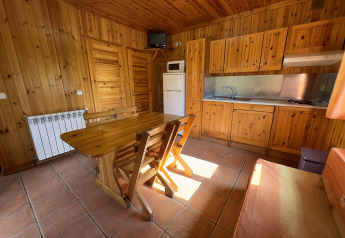 Holzverkleidete Küche und Essbereich im Chalet Bois bei Huttopia Barcelona Pirineos, Spanien.