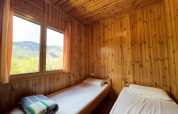 Two single beds in a cozy wood-paneled room at Chalet Bois, Huttopia Barcelona Pirineos, Spain.