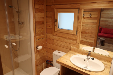 Badkamer in Montana Chalet Vista bij Huttopia Barcelona Pirineos, Spanje, met houten interieur en douche.