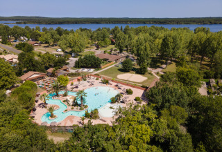 Vue aérienne du parc de vacances Huttopia Lac d'Aureilhan - Mimizan avec piscine, arbres et lac en Nouvelle-Aquitaine.