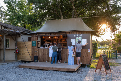 Food truck at Huttopia Lac d'Aureilhan - Mimizan holiday park in France, with people and sunset scenery.