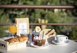 Colazione con croissant, pane, marmellate, caffè e succo d'arancia a Huttopia Lac d'Aureilhan.